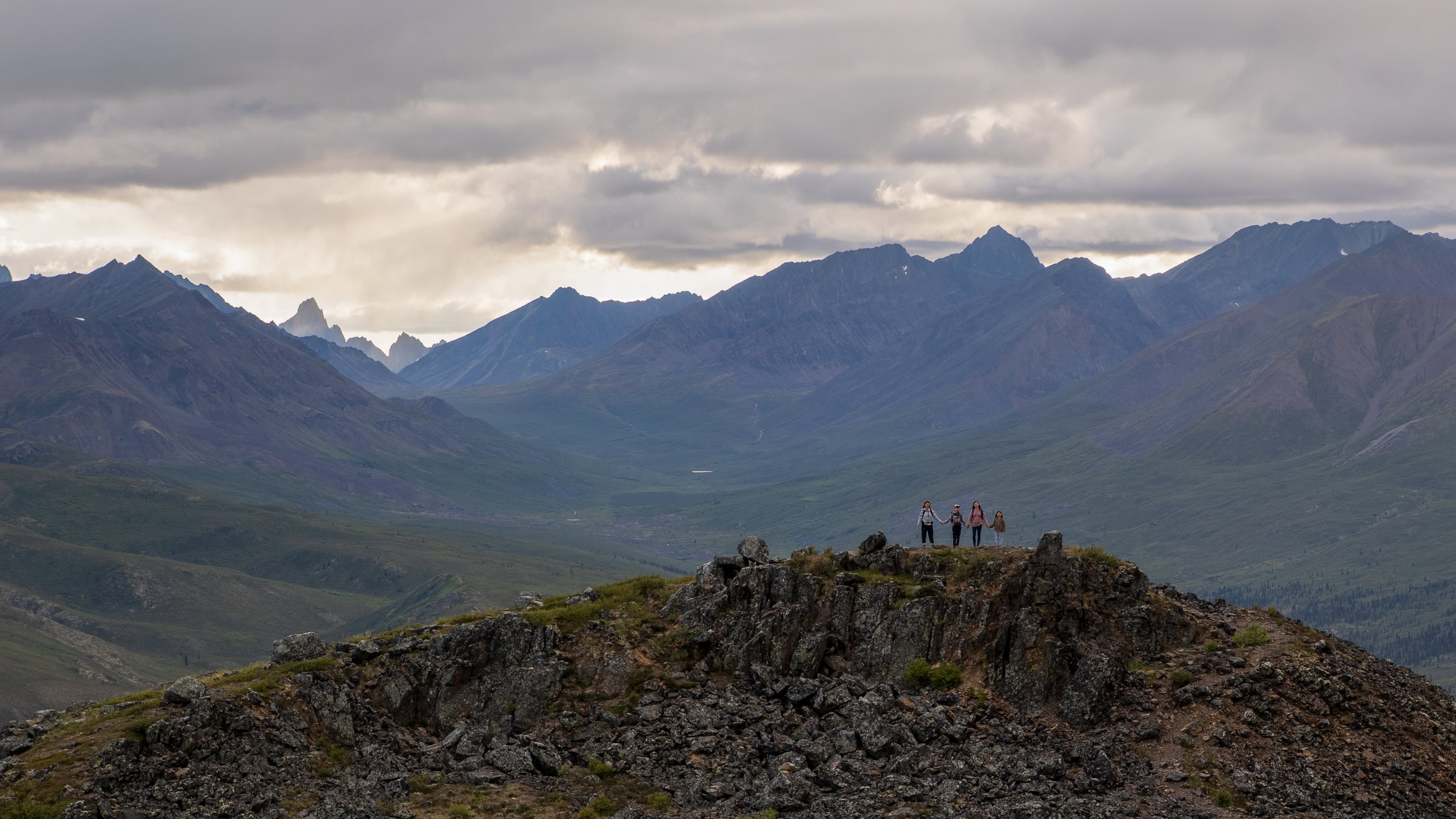 Tombstone Territorial Park photography, a family of four on Goldensides Trail with the Tombstone Range and tundra valley behind, Yukon, by James Wheeler.
