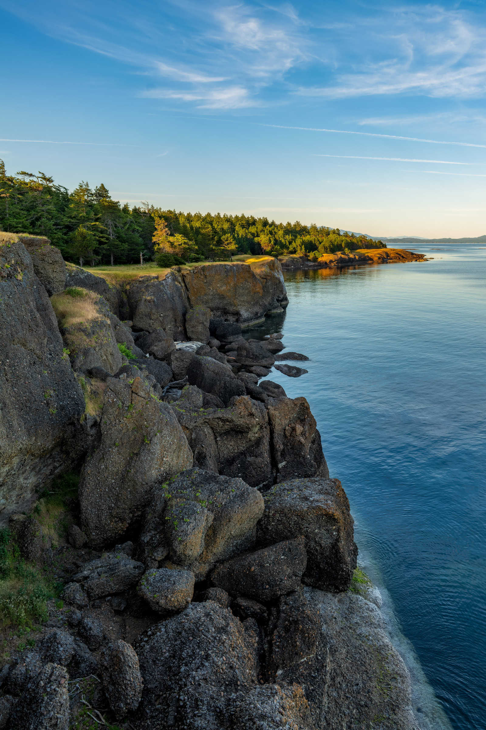 Helliwell Provincial Park wall art showing boulders below the bluffs and evening sun on distant trees, Hornby Island, BC, by James Wheeler.