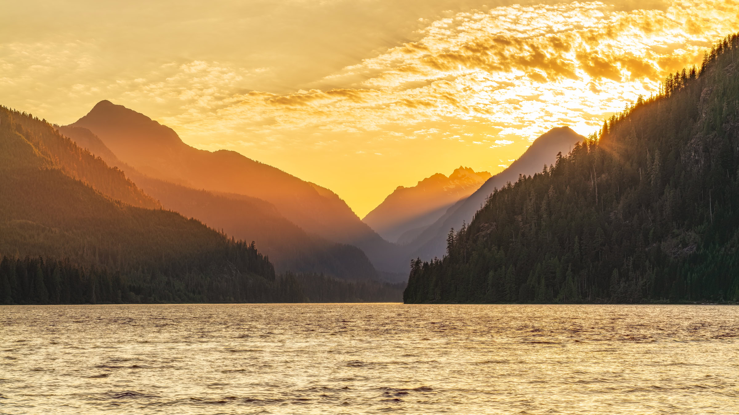 Muchalat Lake wall art showing sunset rays between mountain ridges over the wind-rippled lake near Gold River, Vancouver Island, BC, by James Wheeler.