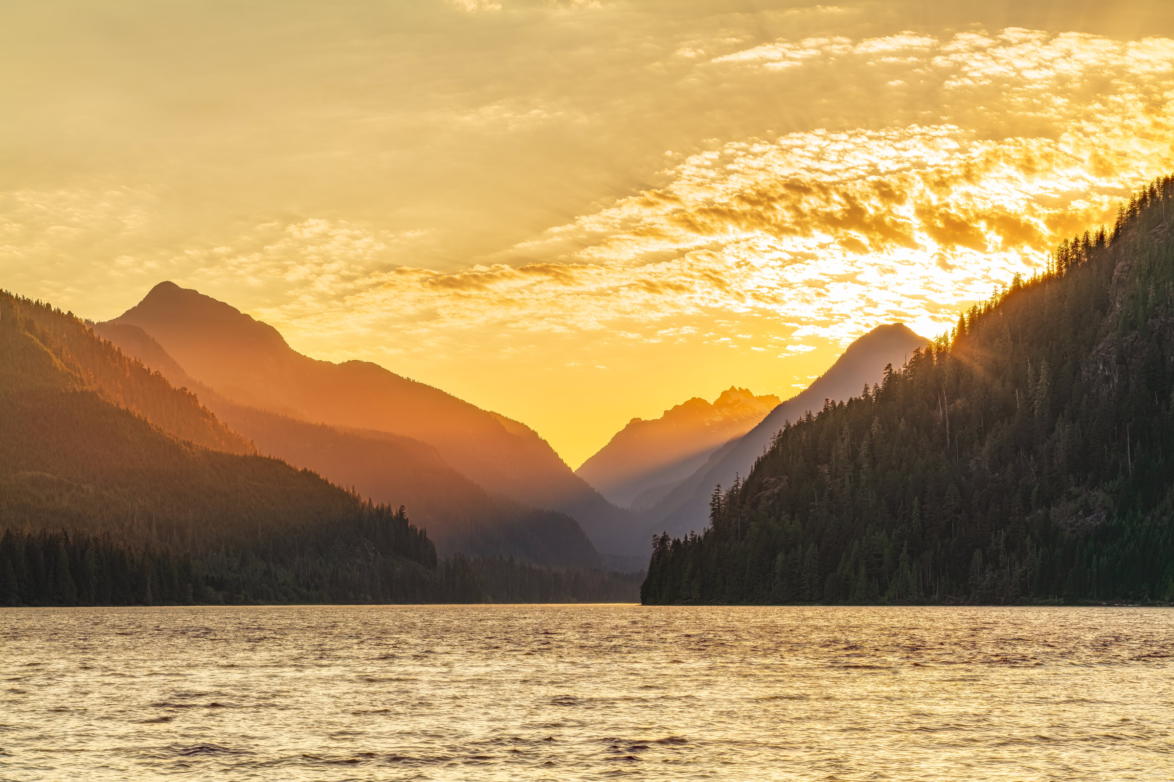 Muchalat Lake wall art showing sunset rays between mountain ridges over the wind-rippled lake near Gold River, Vancouver Island, BC, by James Wheeler.