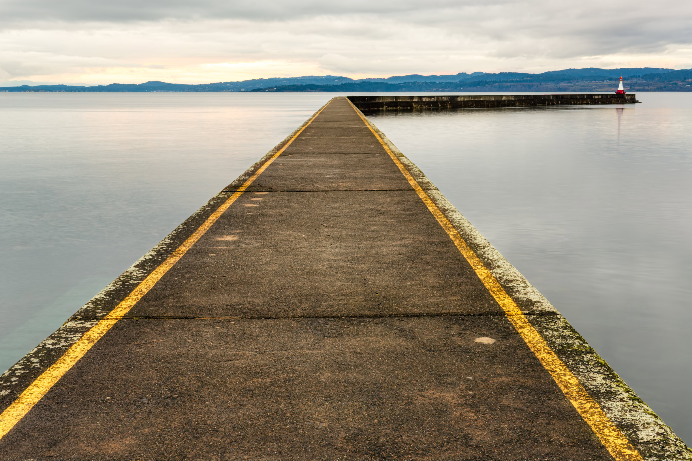 Ogden Point breakwater print showing the concrete walkway and its yellow lines leading to the lighthouse over smooth water, Victoria, BC, by James Wheeler.