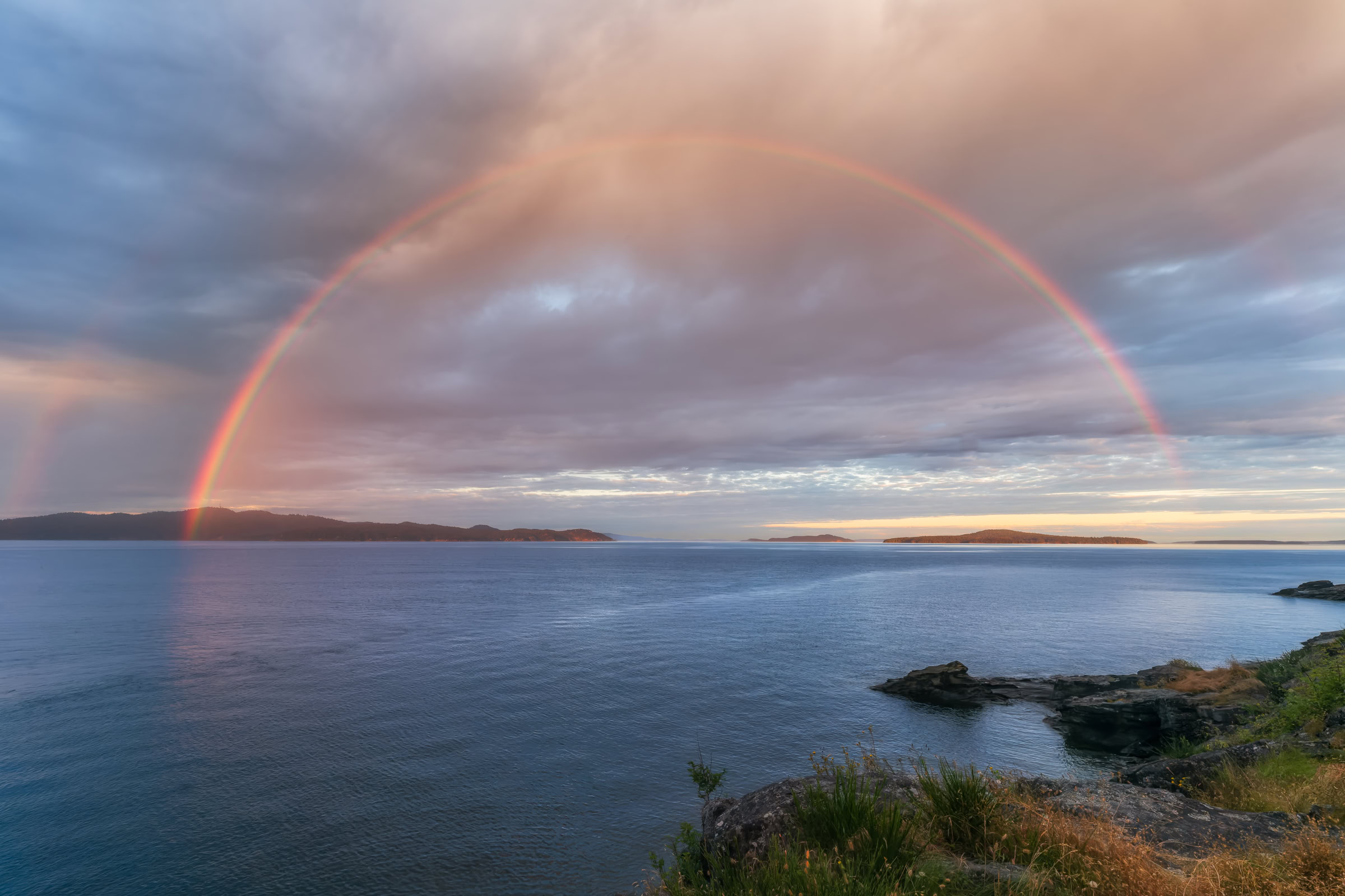 Salt Spring Island photo print of a full rainbow over Pender Island from Beaver Point in Ruckle Provincial Park, BC, at sunset, by James Wheeler.