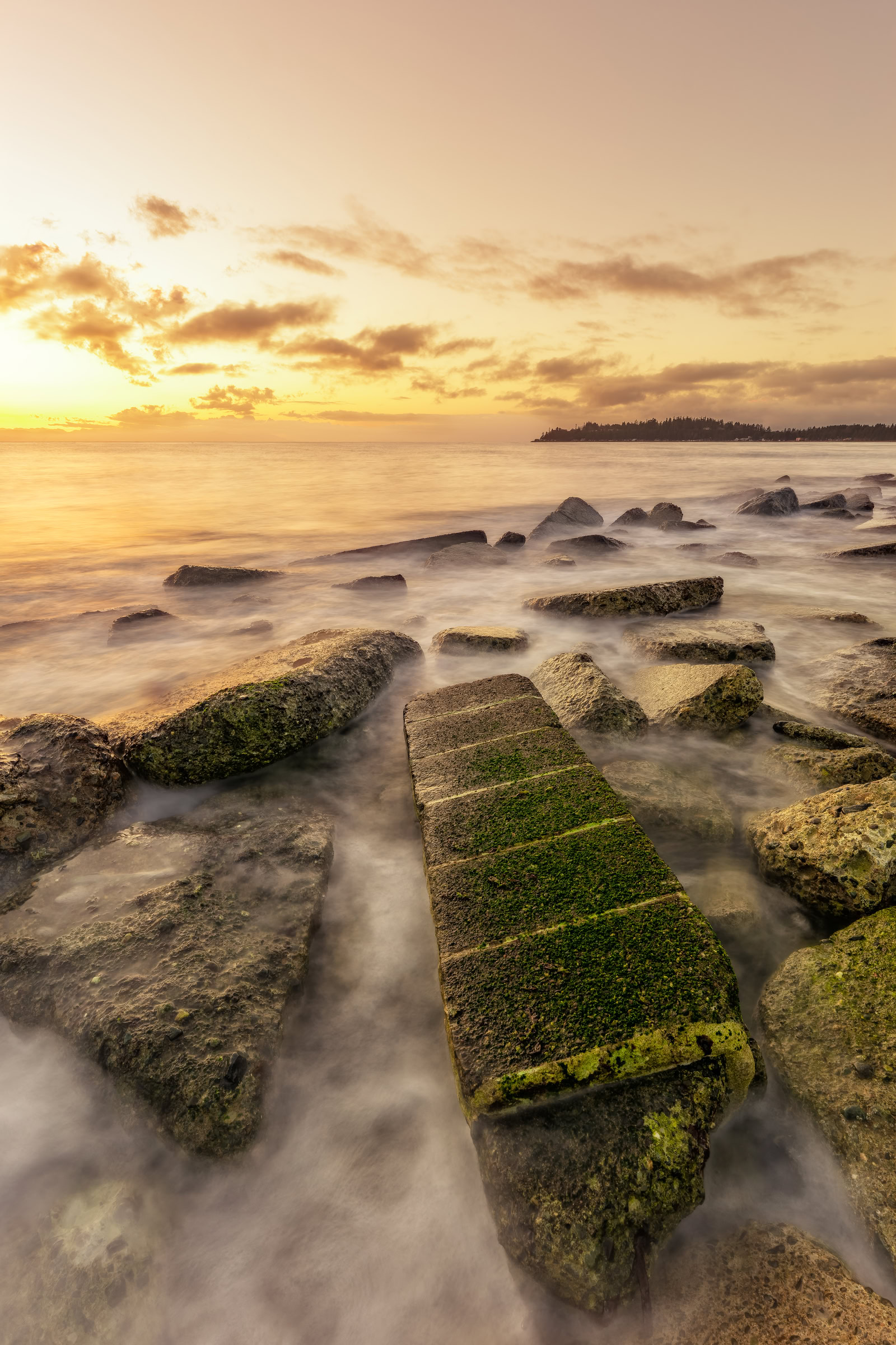 Kye Bay sunrise wall art showing a long exposure of tide over rock slabs at dawn in Comox, Vancouver Island, BC, by James Wheeler.