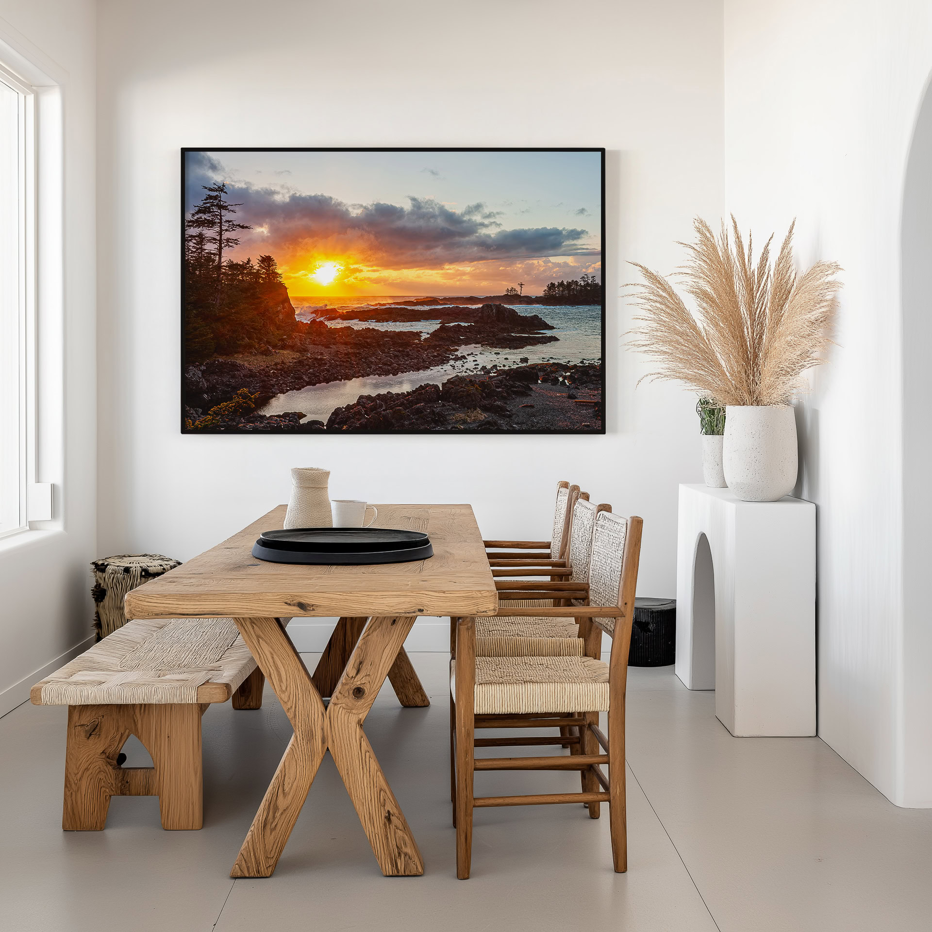 Ucluelet Sunset Through Breaking Clouds print shown on the wall in a dining room.