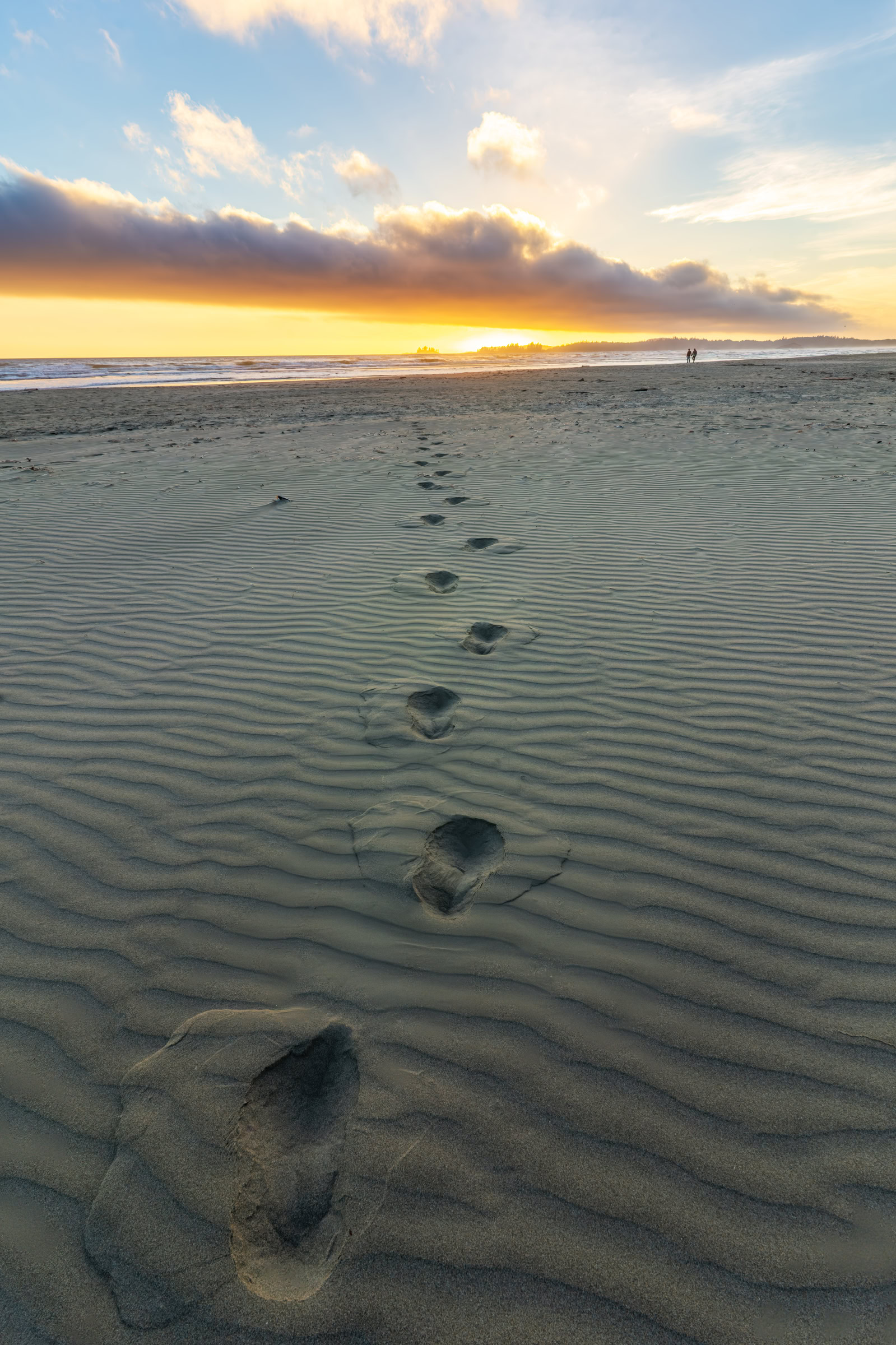 Long Beach Tofino wall art of a single line of footprints across rippled sand toward an August sunset, Pacific Rim National Park, BC, by James Wheeler.